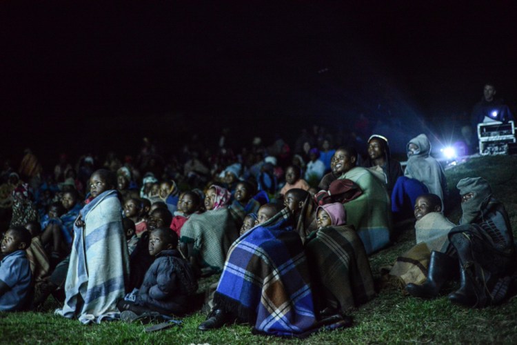 First time at the cinema! Children watch in amazement at the screening in Mokhotlong | © Meri Hyöky Photography